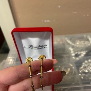 Freida Rothman gold and black earrings.